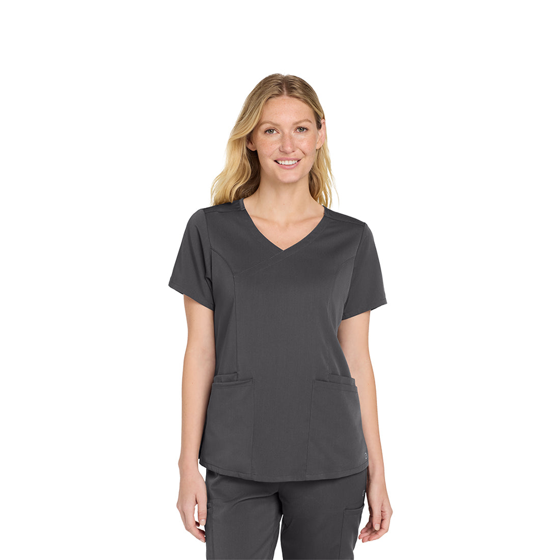 Woman wearing a gray scrub top and pants on a white background