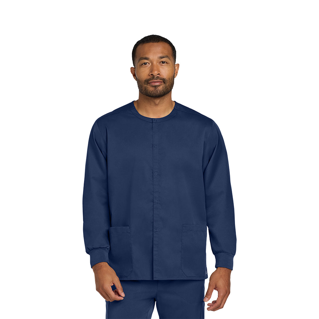 Man wearing a navy blue scrub set on a white background